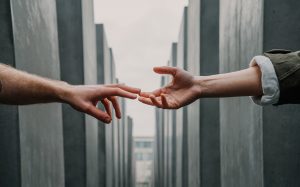 two arms reach out towards each other, as two fingers just touch they experience a sense of connection.