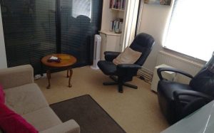 a picture of our counselling room in Bagshot - showing two chairs a sofa and a small table